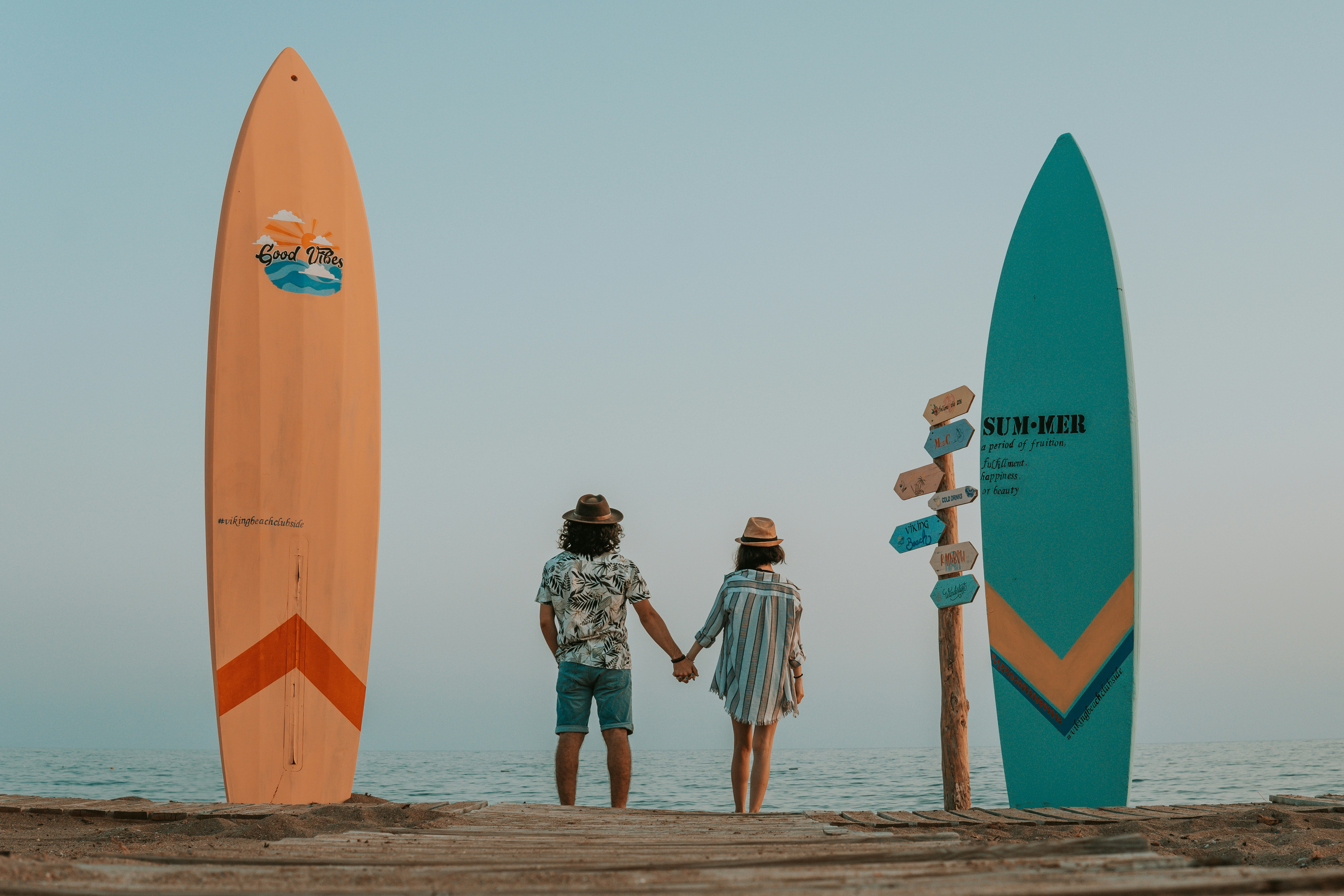 man and woman walking on beach during daytime